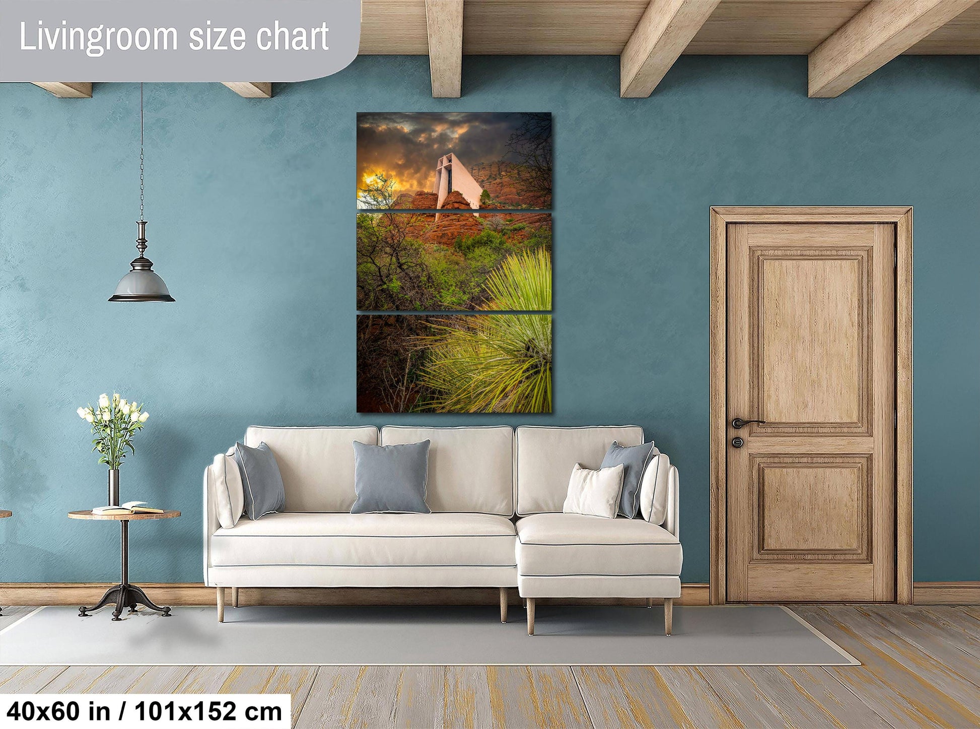 The image is a living room with a white sofa, a wooden door, and a large wall art depicting a desert landscape with a cactus and a person.