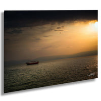 A lone boat sails across a calm body of water, with a dramatic sunset sky in the background.
