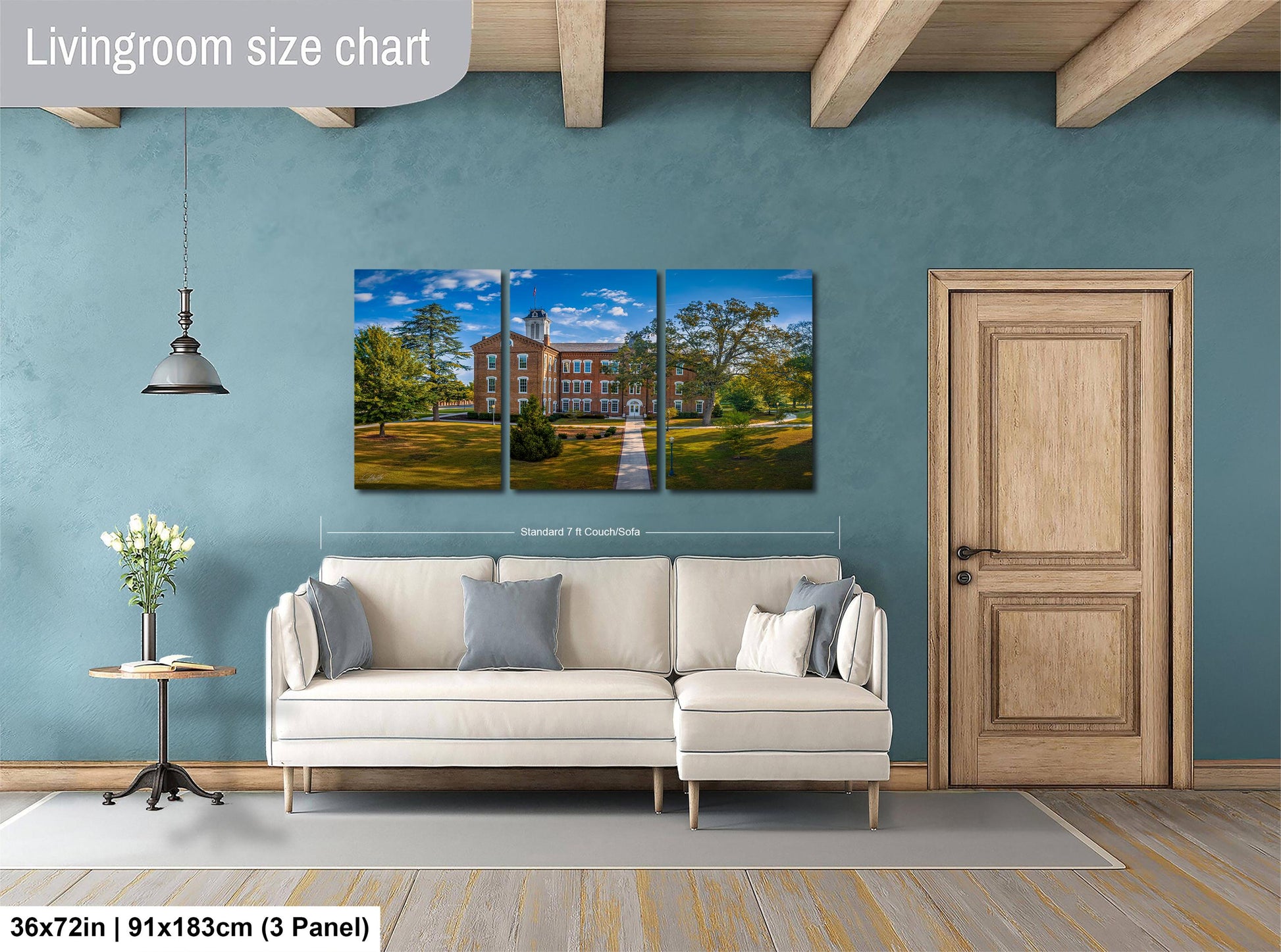 The image is a living room with a large white sofa, a wooden door, and a painting of a building on the wall.