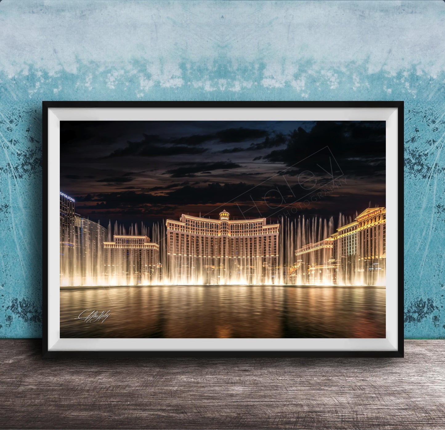 A framed photograph of the Bellagio Fountains in Las Vegas at night, with the fountains illuminated and creating a stunning reflection on the water surface.
