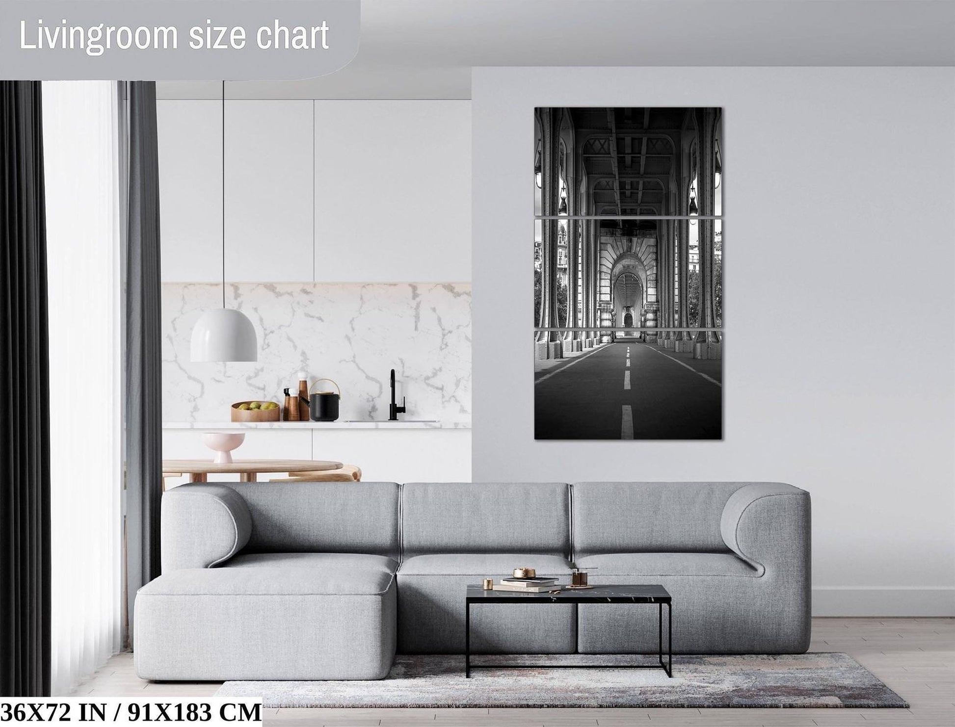 a modern living room with a gray sectional sofa, a coffee table, and a large black and white photograph of a bridge hanging on the wall.