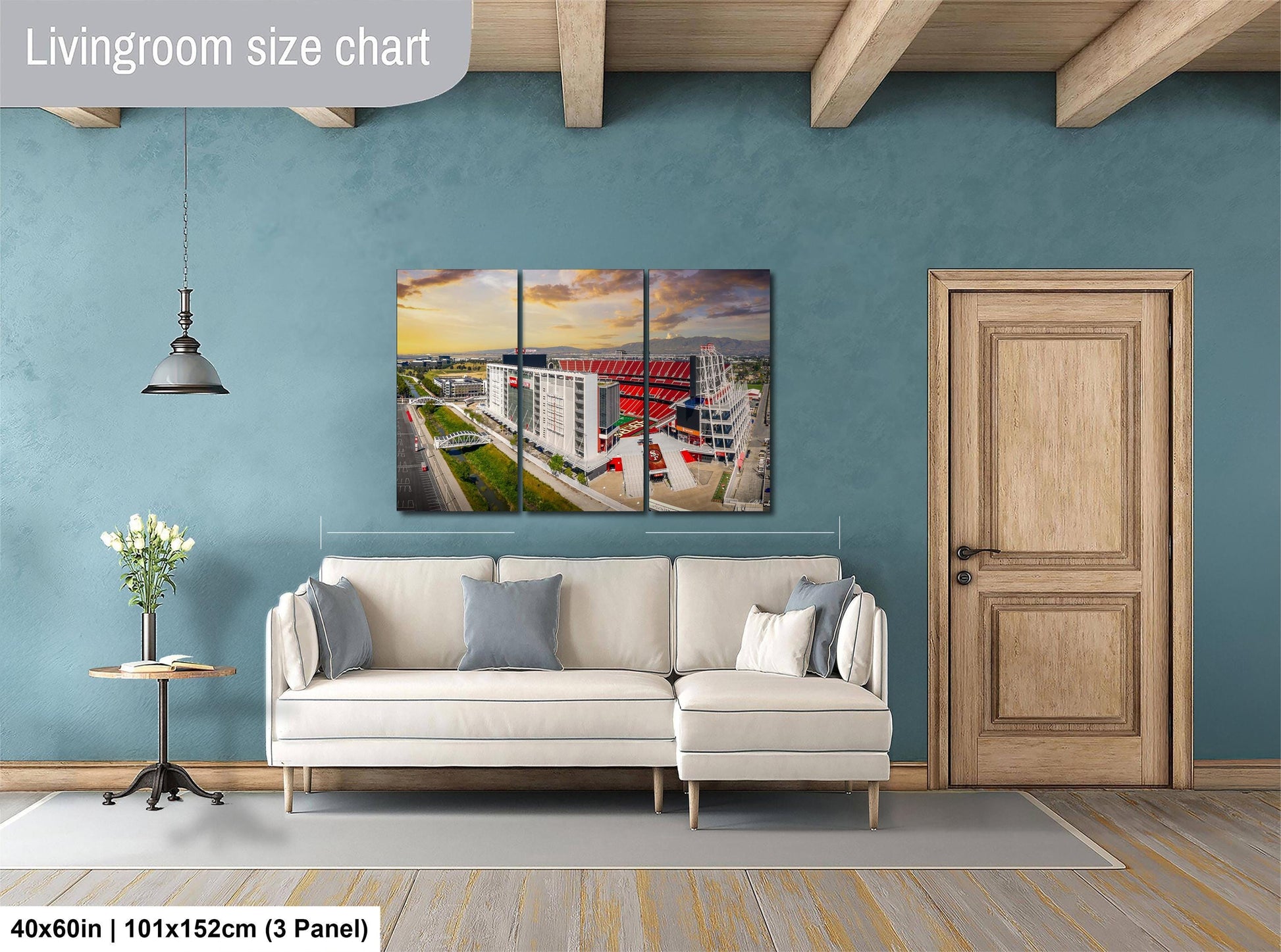 The image is a living room with a white sofa, a wooden door, and a large wall art depicting a cityscape.