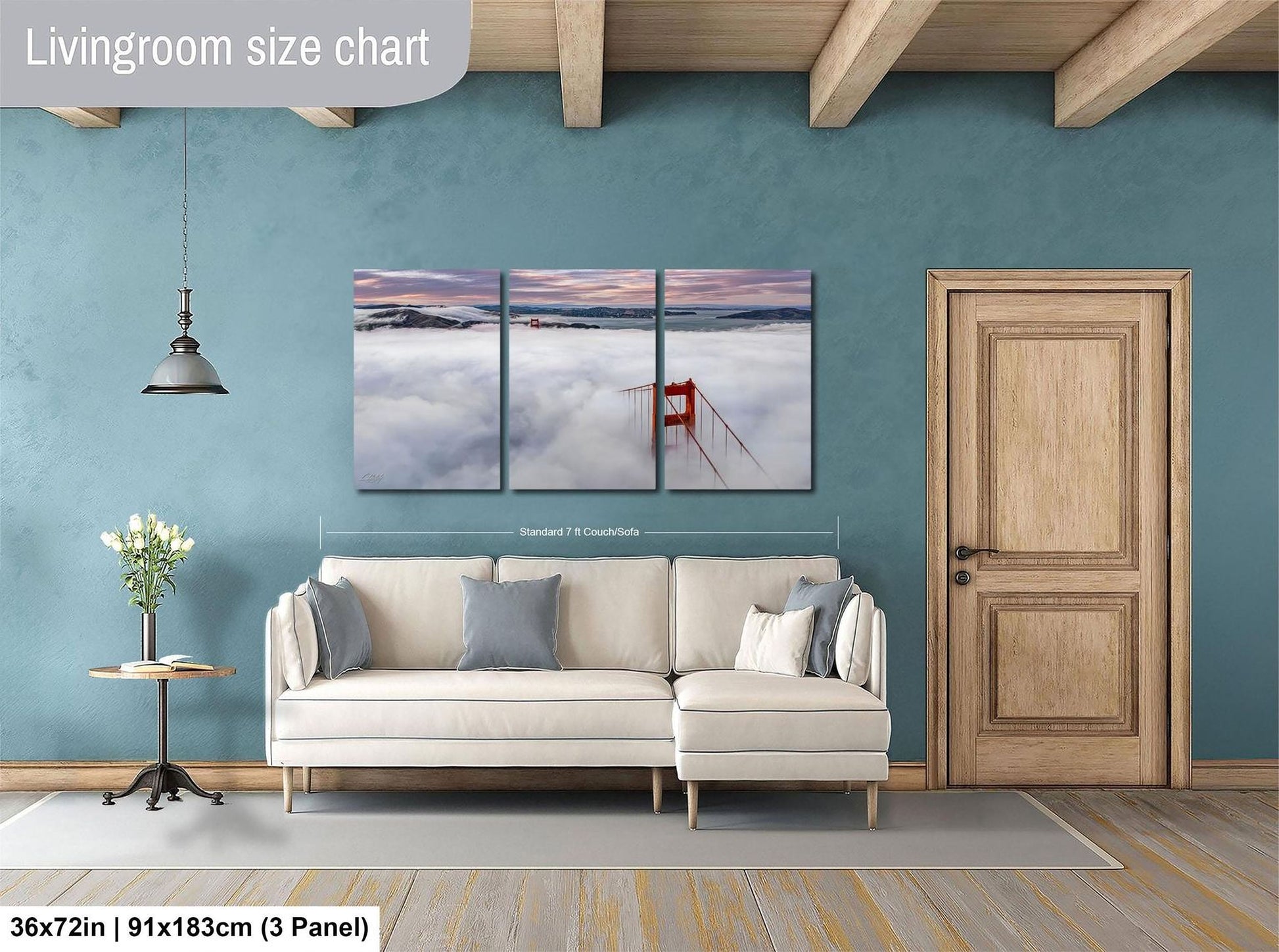 The image is a living room with a large white sofa, a wooden door, and a painting of a red gate on the wall. The painting is divided into three panels, depicting a serene landscape with a red gate in the foreground and a cloudy sky in the background.