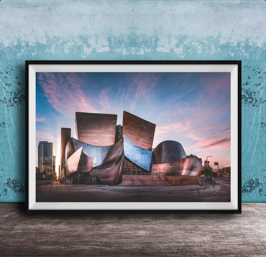 A framed photograph of the Guggenheim Museum in Bilbao, Spain, with its distinctive curved and metallic architecture against a colorful sunset sky.