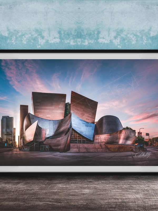 A framed photograph of the Guggenheim Museum in Bilbao, Spain, with its distinctive curved and metallic architecture against a colorful sunset sky.