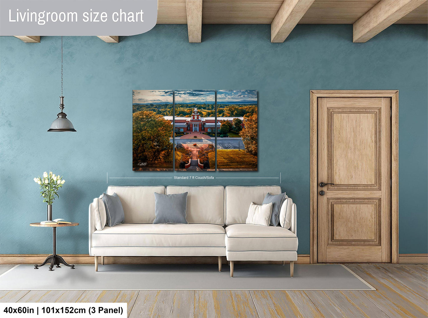 The image is a living room with a large white sofa, a wooden door, and a painting of a building in the background.