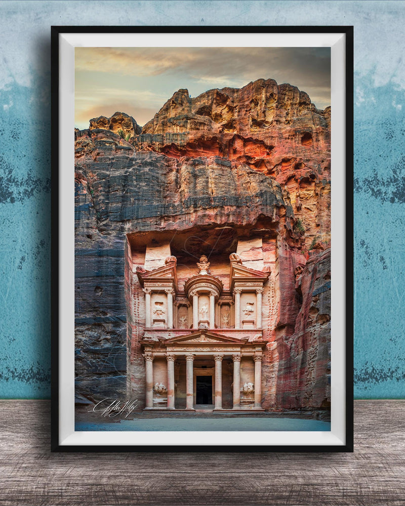 A framed image of the ancient Monastery carved into a cliff face, with a dramatic sky and rocky landscape in the background.