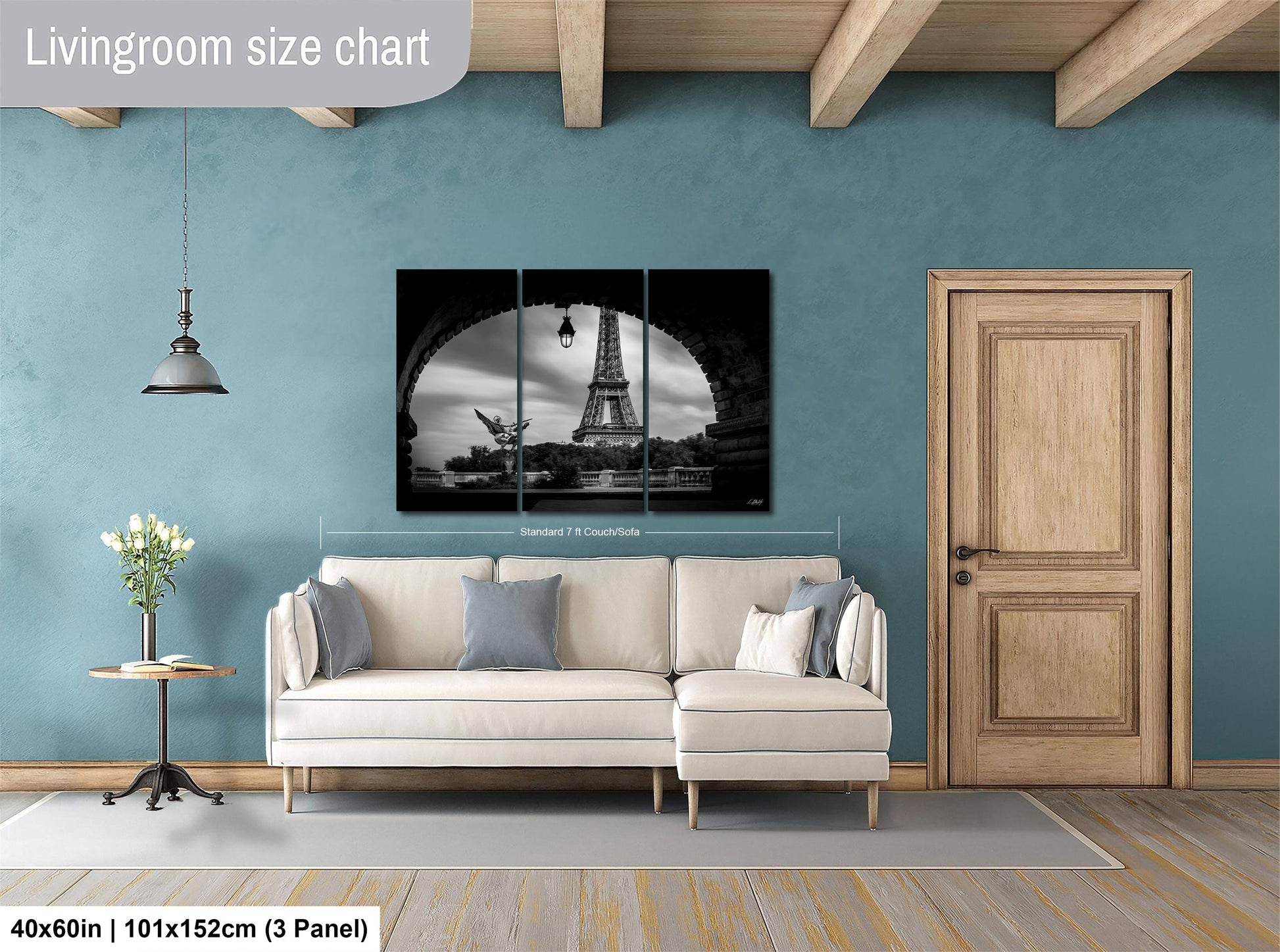 The image is a living room with a large, black and white photograph of the Eiffel Tower displayed on the wall. The room has a white sofa, a wooden door, and a wooden table with a vase of flowers. The living room size chart indicates that the space is approximately 40'x60', or 101'x152', with a 3' panel.