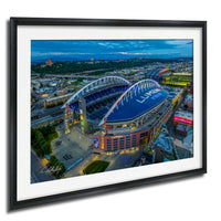 a large stadium with a curved roof, surrounded by a cityscape with buildings and roads.