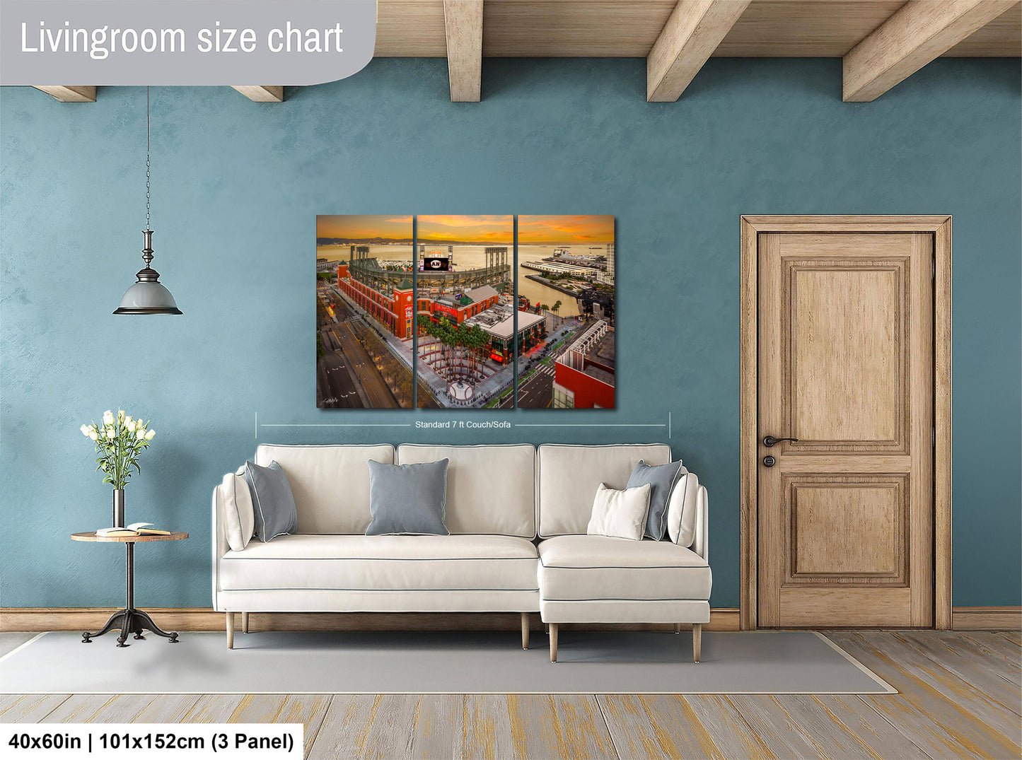 The image is a living room with a large white sofa, a wooden door, and a painting of a cityscape hanging on the wall.