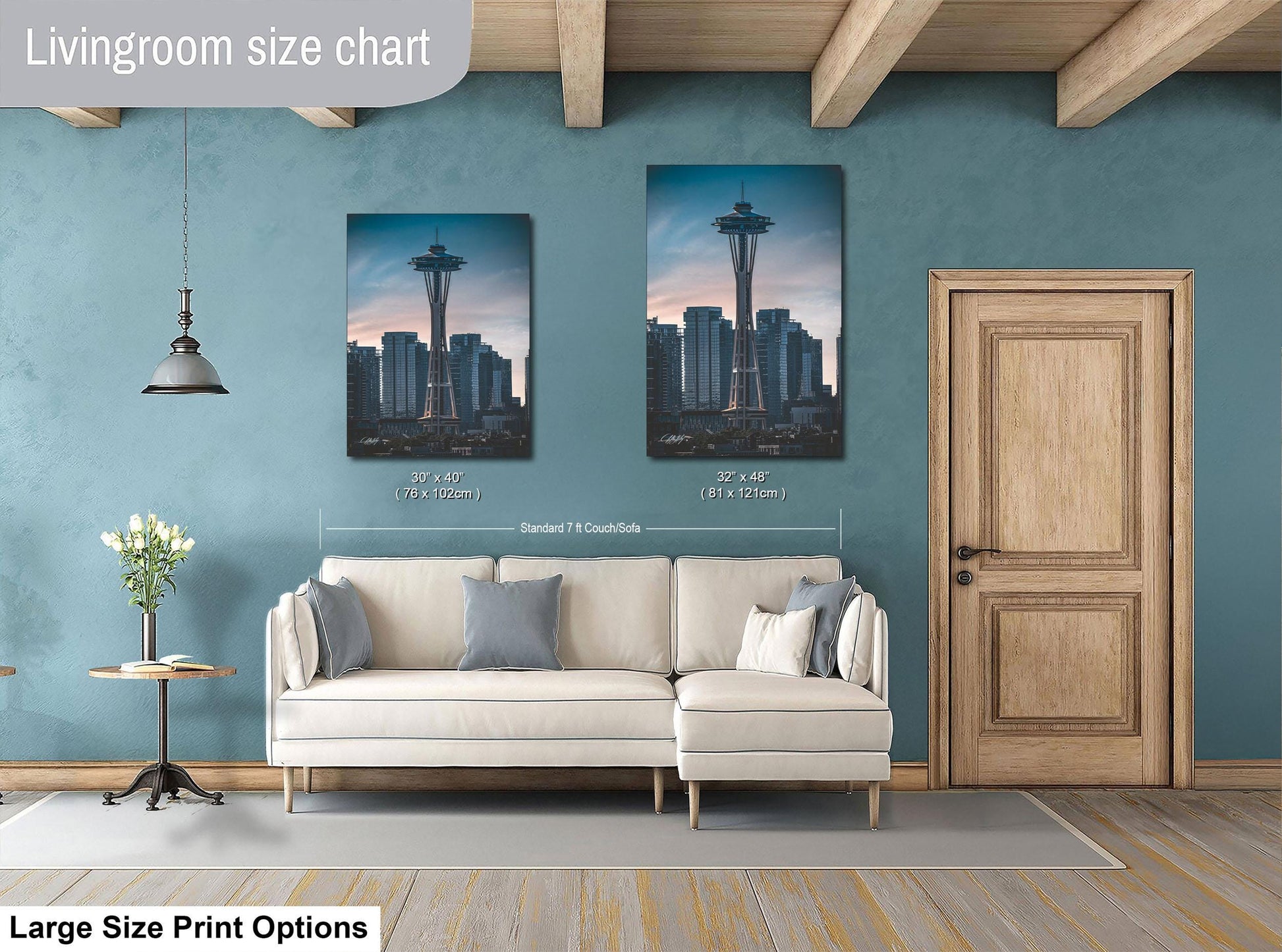 a living room with a white sofa, a wooden door, and two framed pictures of the Space Needle on the wall.
