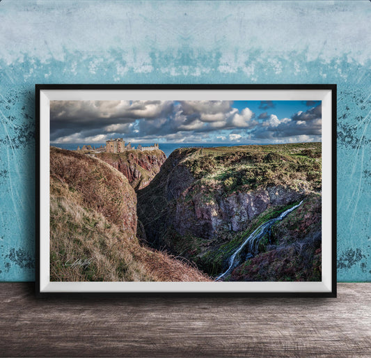 The image is a framed photograph depicting a scenic landscape with a waterfall cascading down a steep cliff face. The photograph is set against a blue wall, creating a striking contrast with the natural elements. The image showcases the beauty of the outdoors and the power of nature.