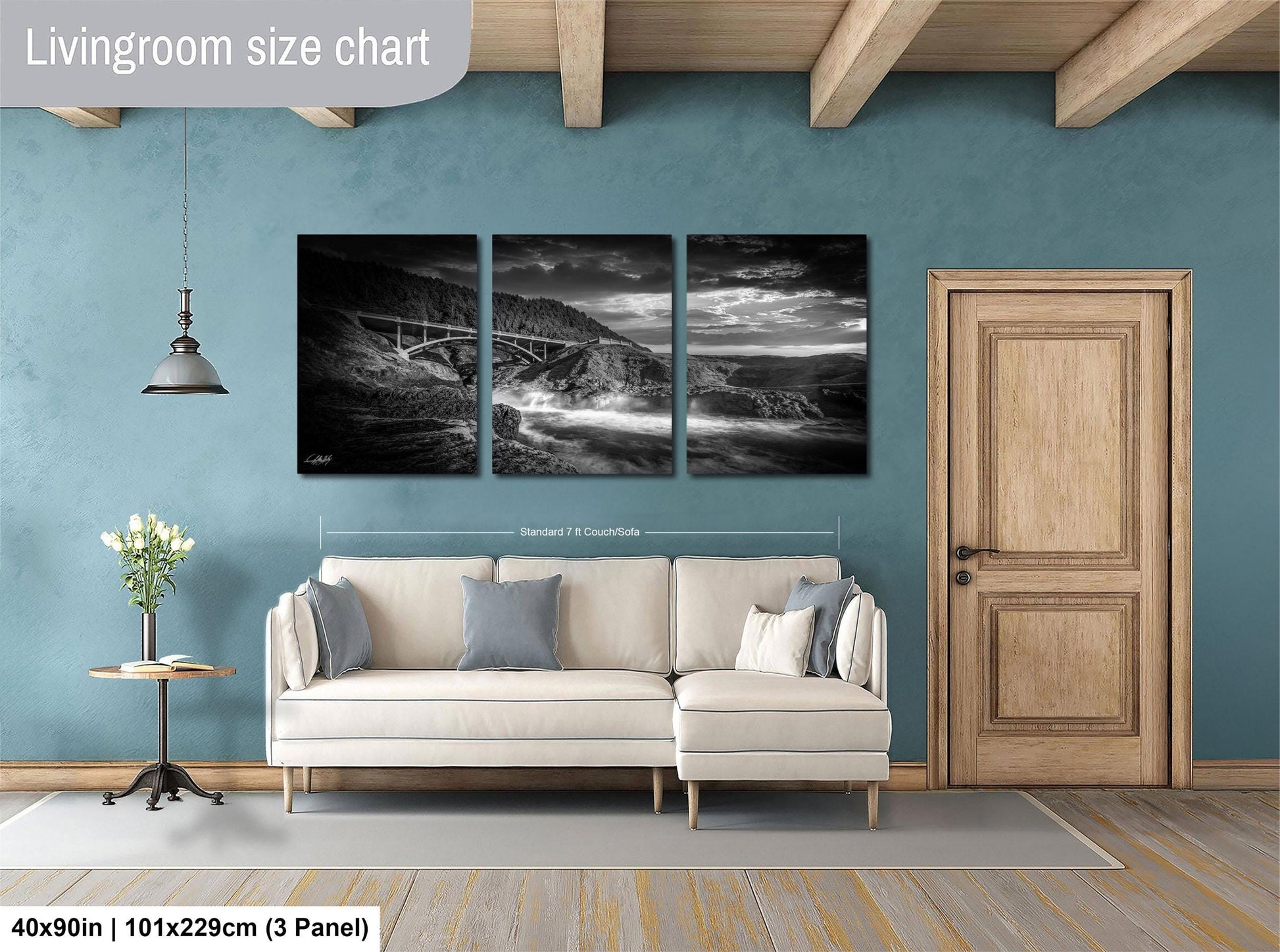 The image is a living room with a large white sofa, a wooden door, and a painting of a landscape on the wall.