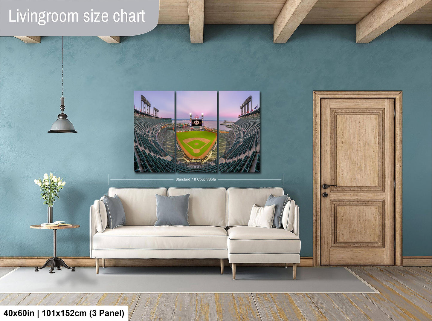 The image is a living room with a large wall-mounted painting depicting a baseball stadium. The painting is divided into three panels, with the top and bottom panels showing the stadium and the middle panel showing the field. The painting is framed by a wooden door and a white sofa, creating a cozy and inviting atmosphere.