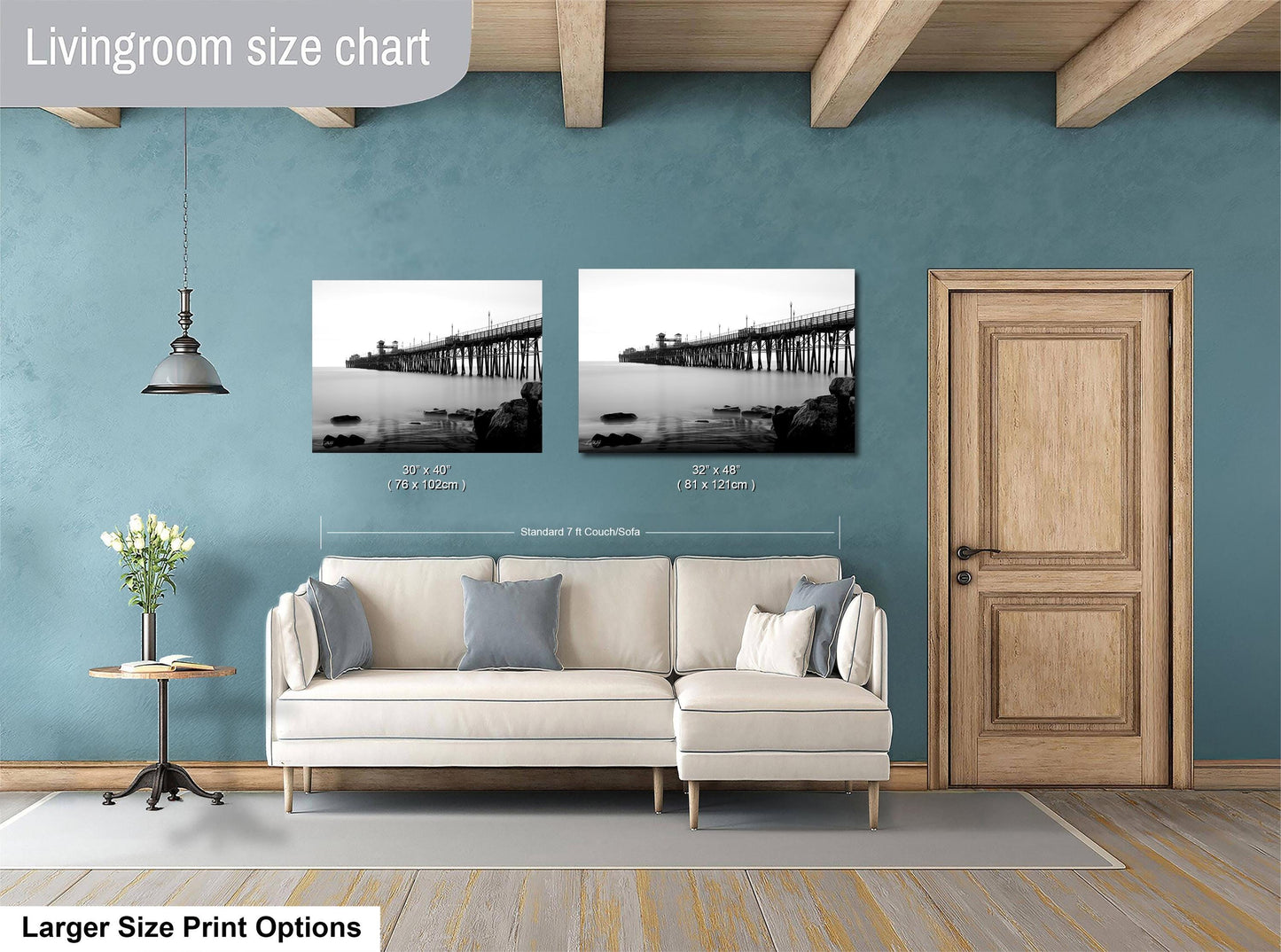 a living room with a white sofa, a wooden door, and a framed photograph of a bridge hanging on the wall.