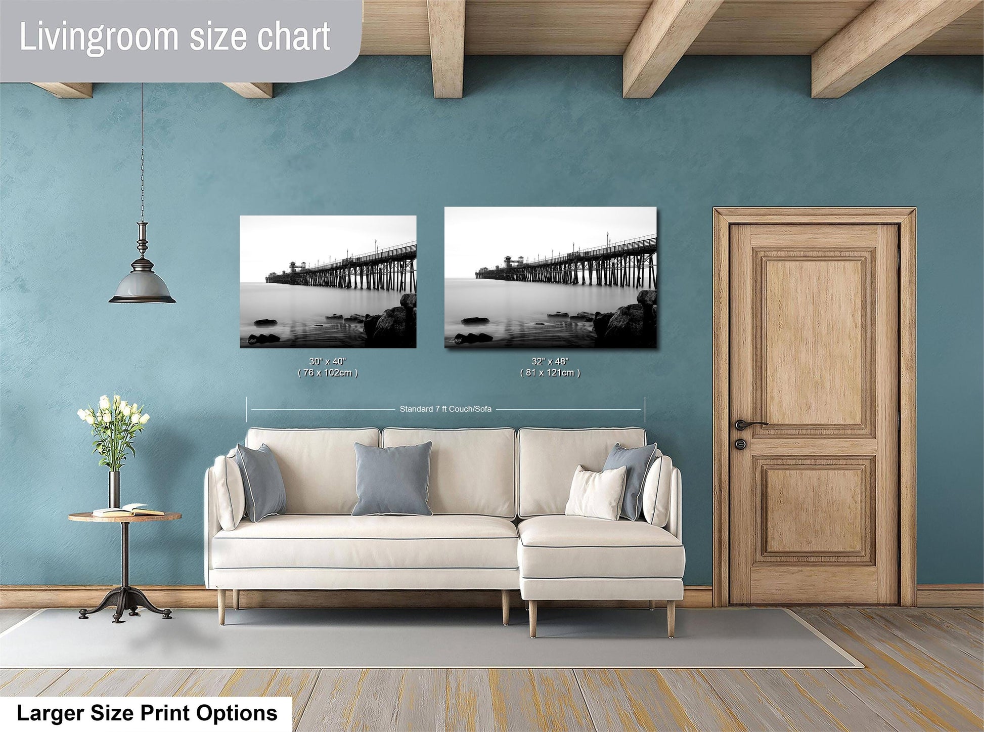 a living room with a white sofa, a wooden door, and a framed photograph of a bridge hanging on the wall.