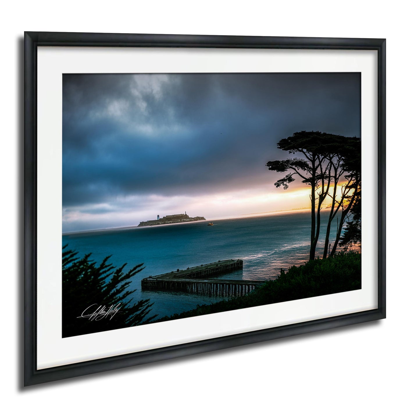 A framed photograph depicting a serene coastal scene with a large cruise ship in the distance, a pier, and a dramatic sky with clouds and a colorful sunset.