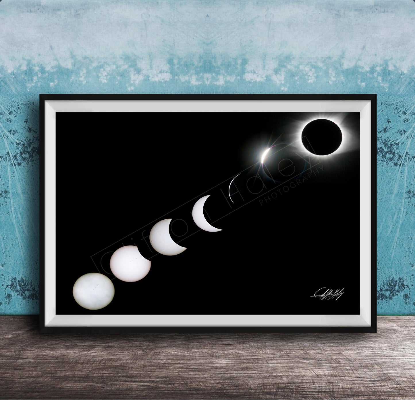 A framed image depicting the solar eclipse, showing the moon transitioning from a crescent to a full moon, with the sun partially obscured by the moon.