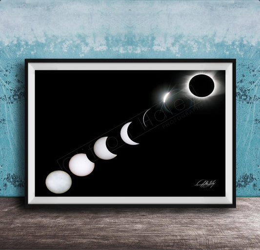 A framed image depicting the solar eclipse, showing the moon transitioning from a crescent to a full moon, with the sun partially obscured by the moon.