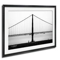 A black and white photograph of the Golden Gate Bridge, a suspension bridge with a distinctive tower and cables, spanning across a body of water.