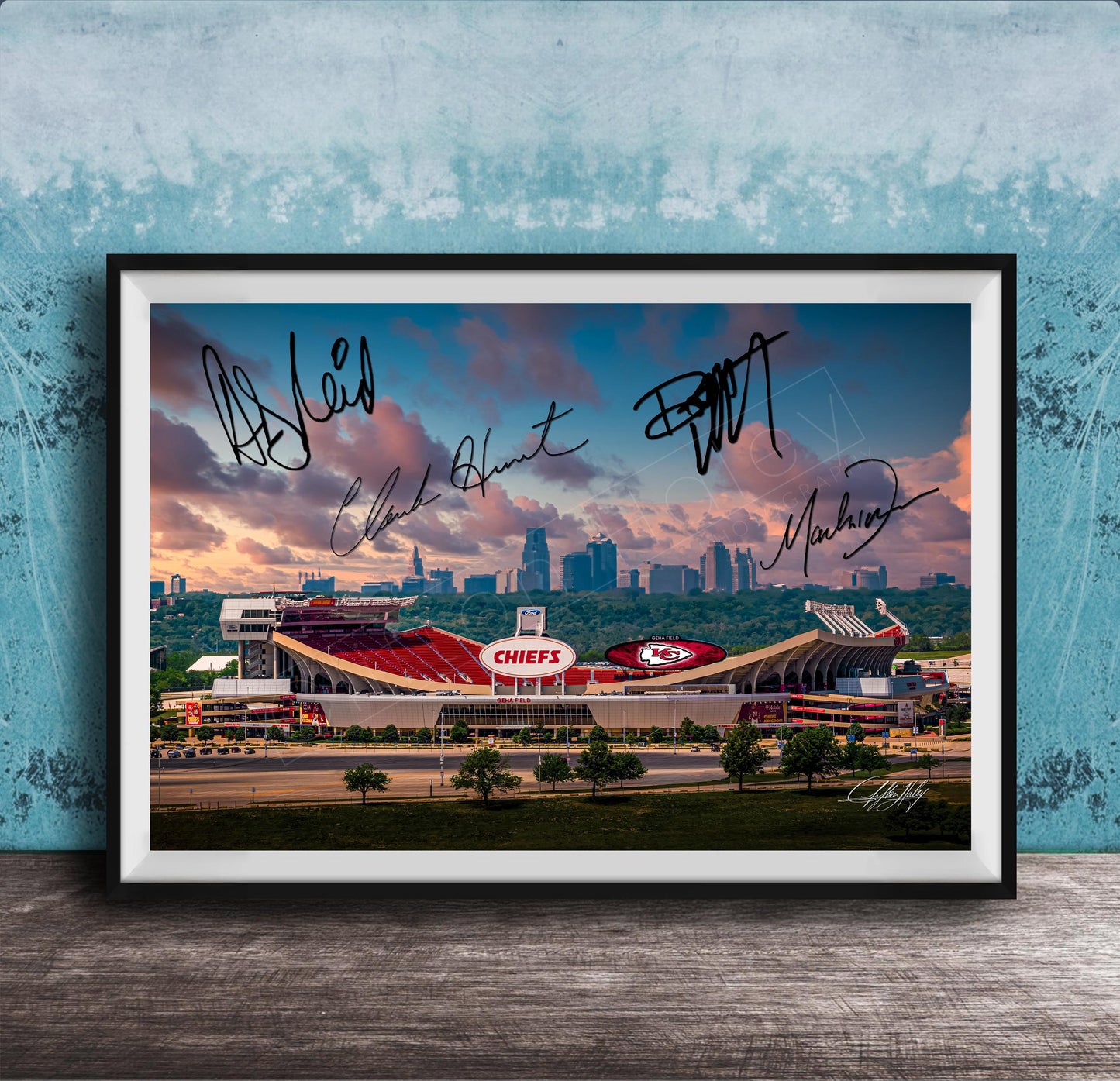 A framed photograph of a football stadium with the word "CHIEF" prominently displayed, along with the signatures of several people.