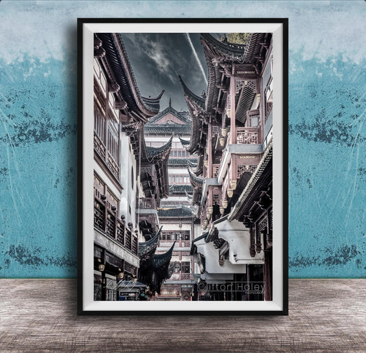 A framed photograph of a traditional Chinese street lined with ornate buildings and pagodas, set against a blue textured background.