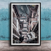 A framed photograph of a traditional Chinese street lined with ornate buildings and pagodas, set against a blue textured background.