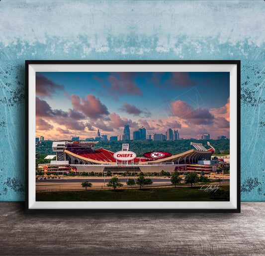 A framed photograph of the Kansas City Chiefs football stadium, with the city skyline in the background.