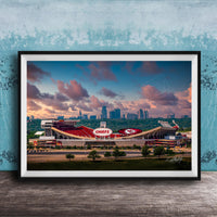 A framed photograph of the Kansas City Chiefs football stadium, with the city skyline in the background.
