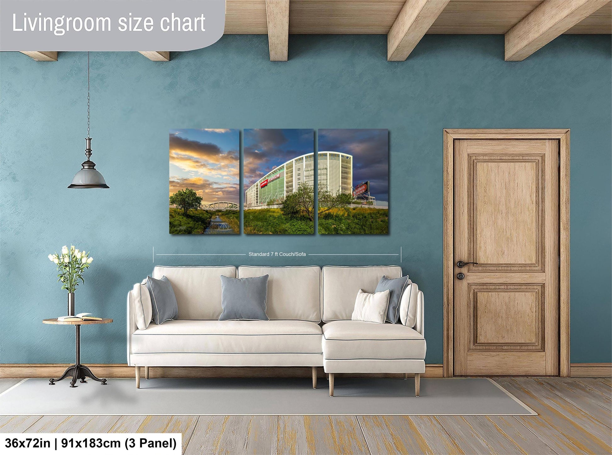 The image is a living room with a large white sofa, a wooden door, and a painting of a building on the wall.