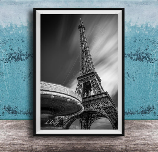 A black and white photograph of the Eiffel Tower in Paris, France, with a blurred background.