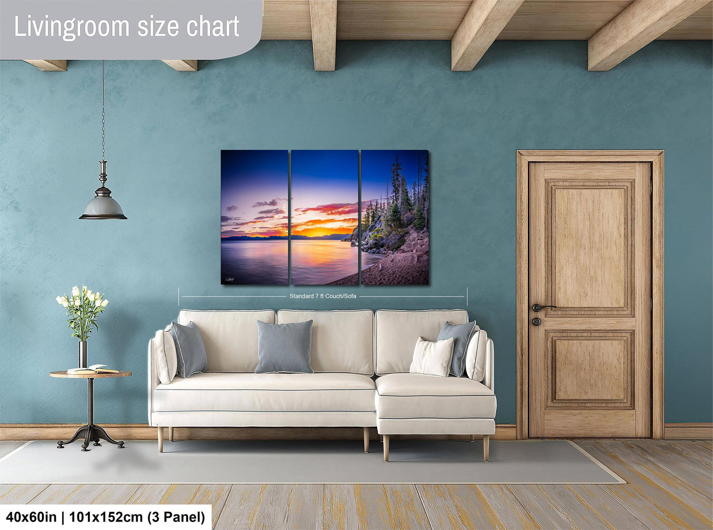 The image is a living room with a large, colorful painting of a sunset over a body of water hanging on the wall. The painting is divided into three panels, and the living room has a white sofa, a wooden door, and a small table with a vase of flowers.