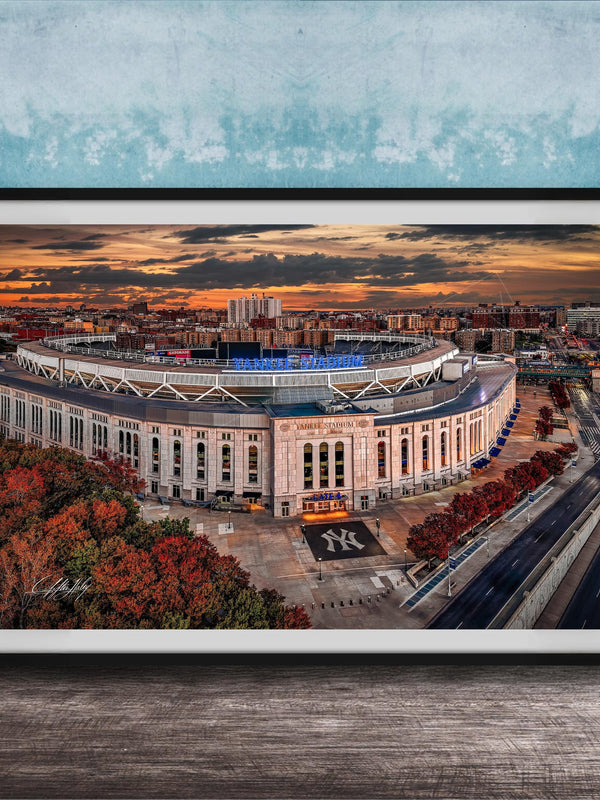 The image is a framed photograph of the Yankee Stadium in New York City, with a stunning sunset in the background.