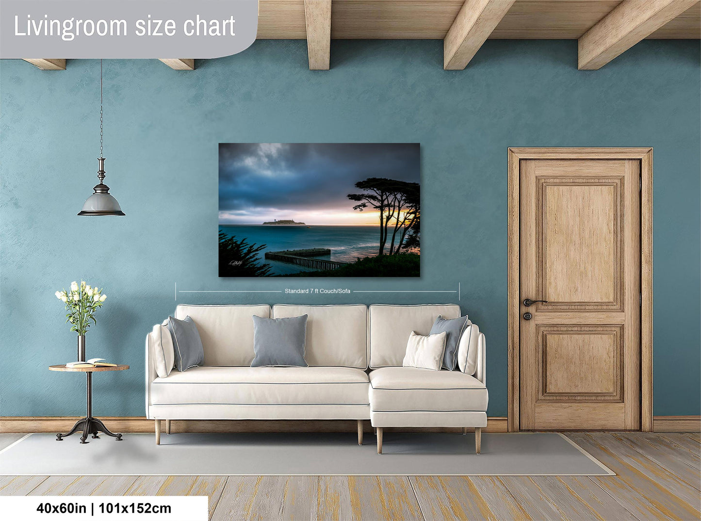 a living room with a large painting of a serene landscape hanging on the wall. The painting features a tranquil scene of a body of water, possibly a lake or ocean, with a sunset in the background. The room is furnished with a white sofa and a wooden door, creating a cozy and inviting atmosphere.