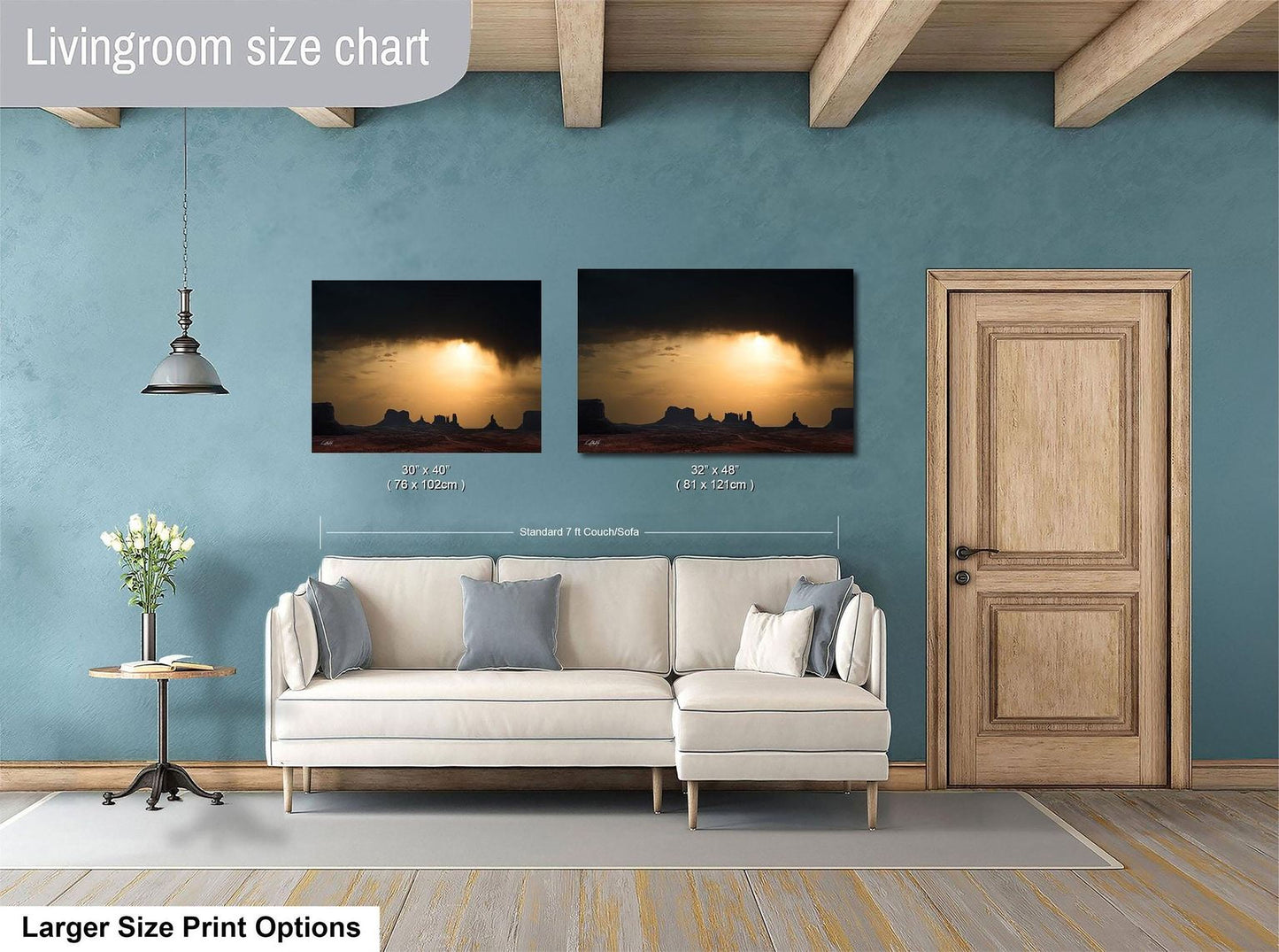 a living room with a white sofa, a wooden door, and two framed landscape paintings hanging on the wall.