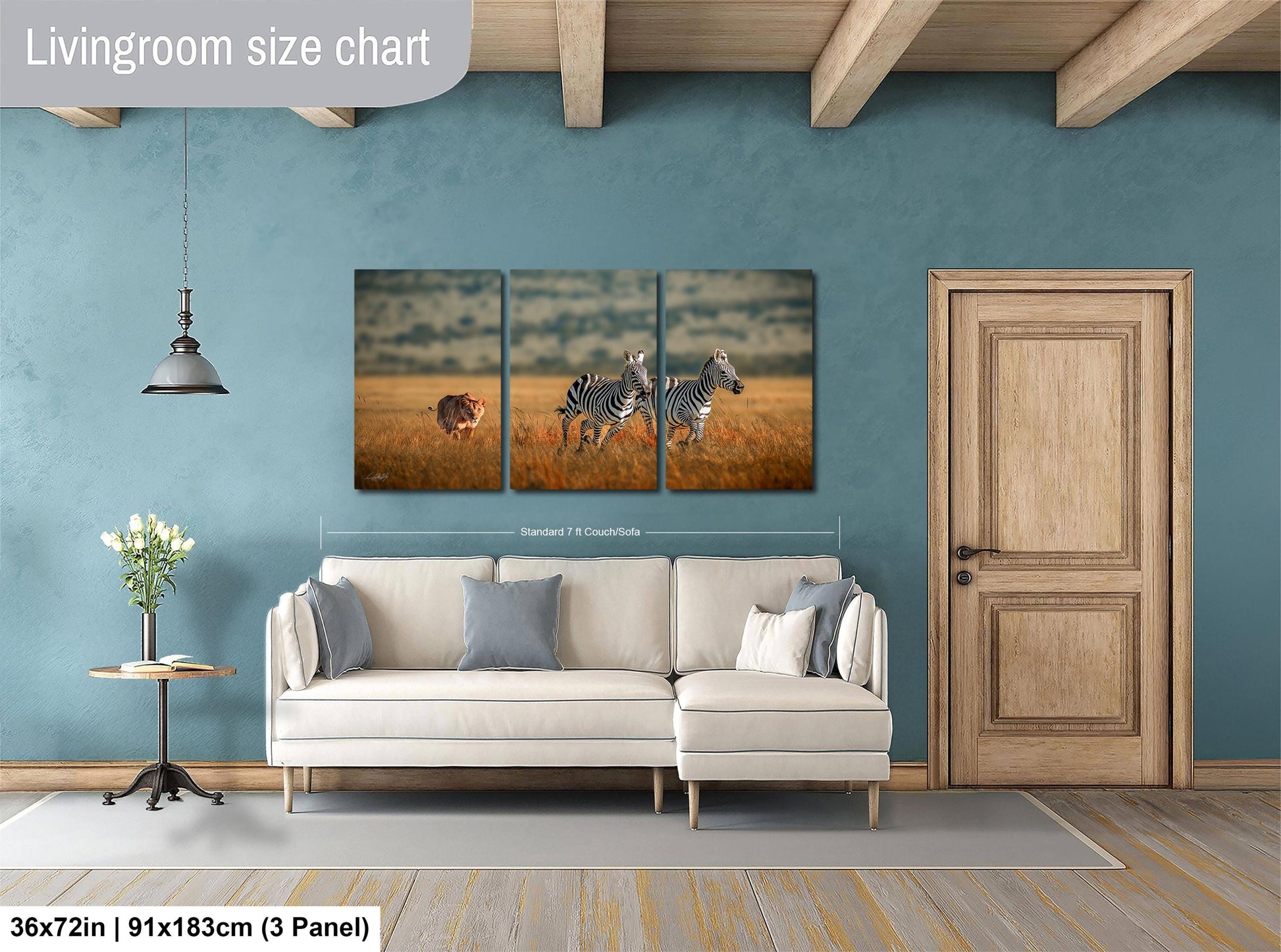 The image is a living room with a large wall art depicting two zebras in a field. The wall art is a collage of three smaller images, and the living room has a white sofa, a wooden door, and a small table with a vase of flowers.