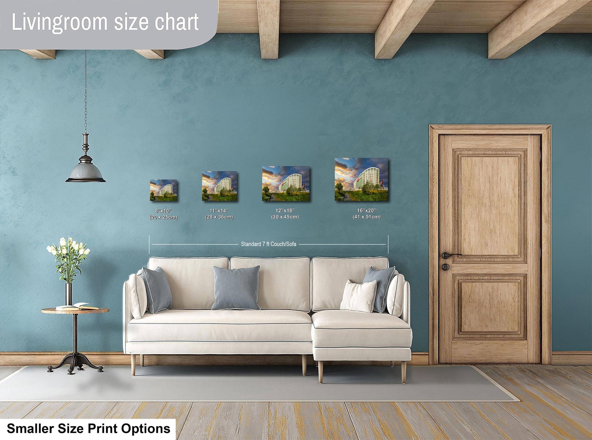 a living room with a white sofa, a wooden door, and a hanging light fixture. There are four framed pictures of buildings displayed on the wall above the sofa.