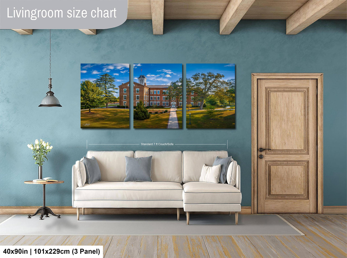 The image is a living room with a large white sofa, a wooden door, and a painting of a building on the wall.