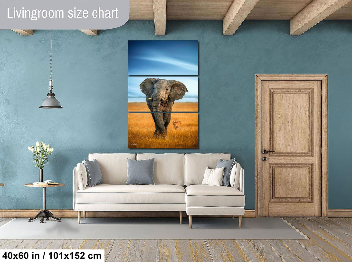 a living room with a large painting of an elephant on the wall, a white sofa, a wooden door, and a small table with a vase of flowers.