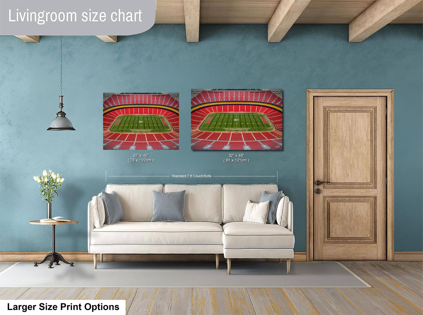 a living room with a white sofa, a wooden door, and two framed pictures of a stadium on the wall.