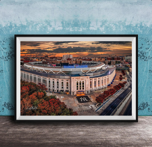 The image is a framed photograph of the Yankee Stadium in New York City, with a stunning sunset in the background.