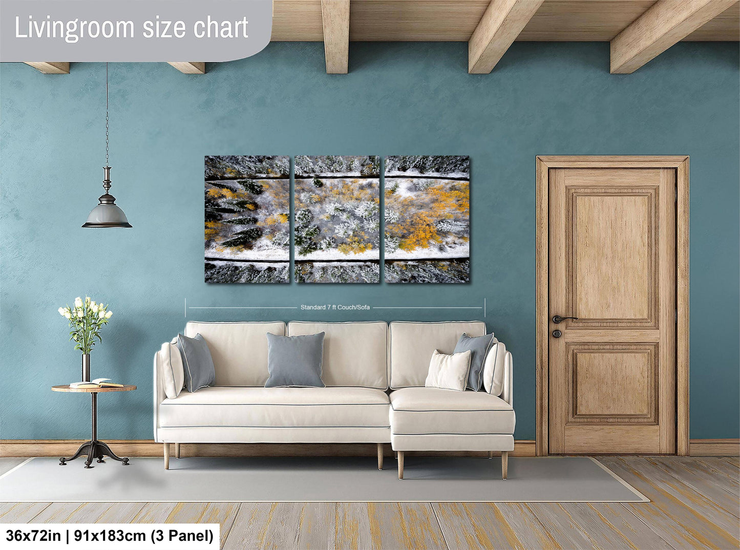 The image is a living room with a large white sofa, a wooden door, and a painting of a snowy landscape hanging on the wall.