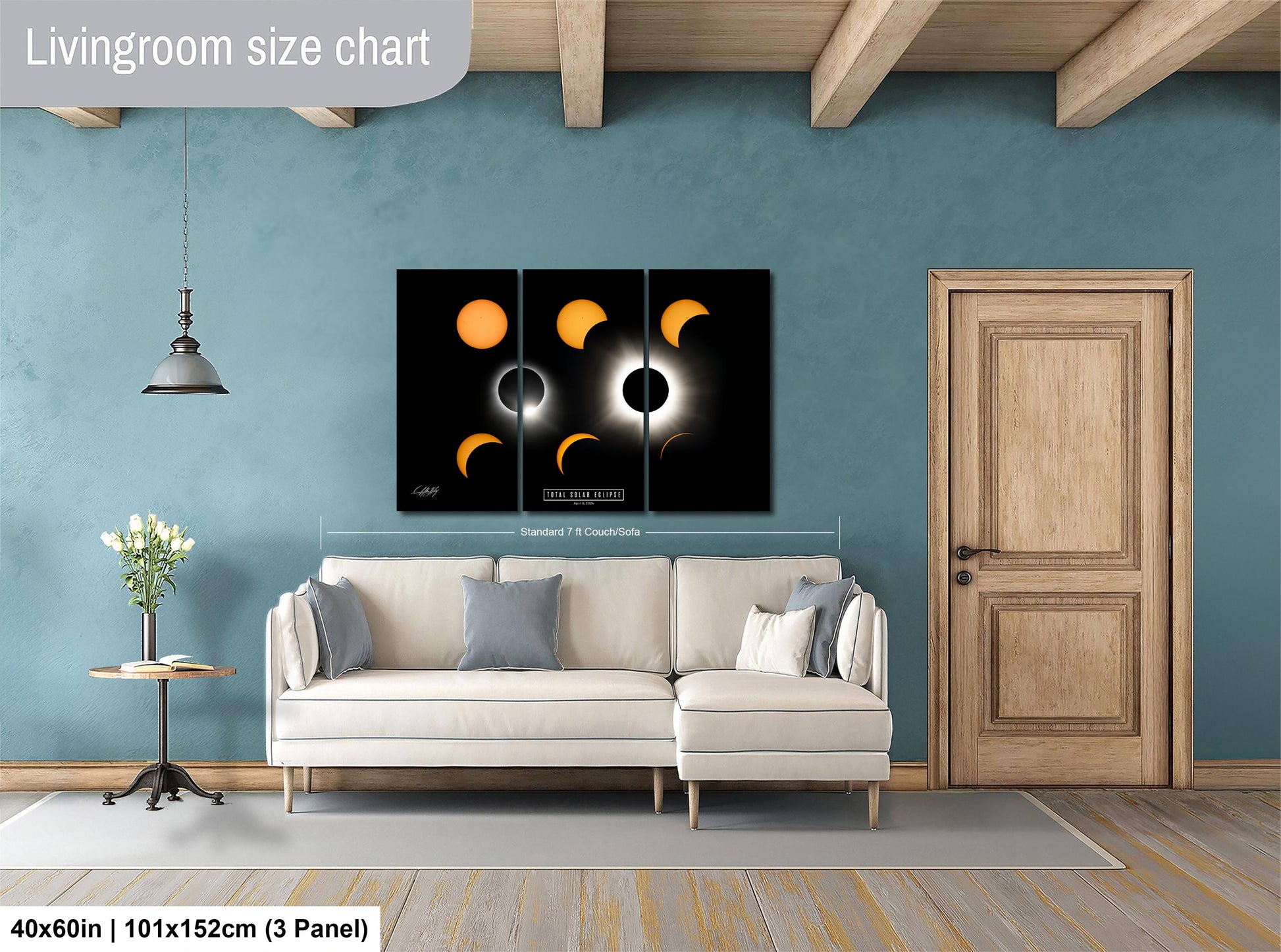 The image is a living room with a white sofa, a wooden door, and a large wall art depicting the solar eclipse. The living room has a blue wall and a wooden floor.