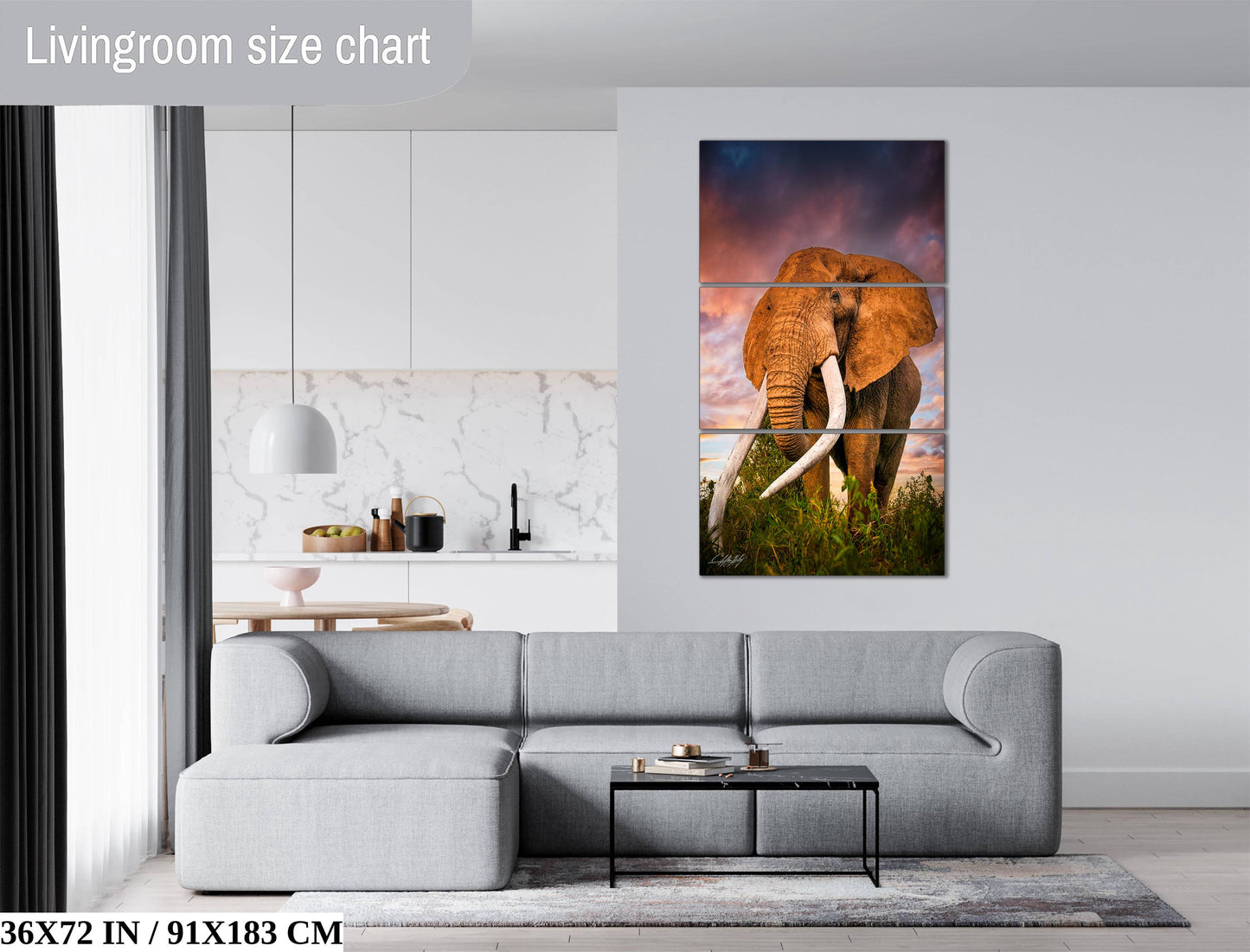 The image is a living room with a gray sofa, a coffee table, and a large painting of an elephant on the wall.