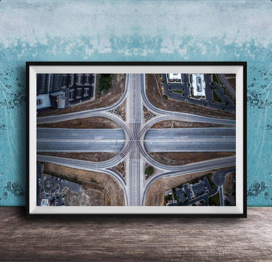 The image is an aerial view of a highway intersection with multiple lanes and exits, surrounded by buildings and greenery.