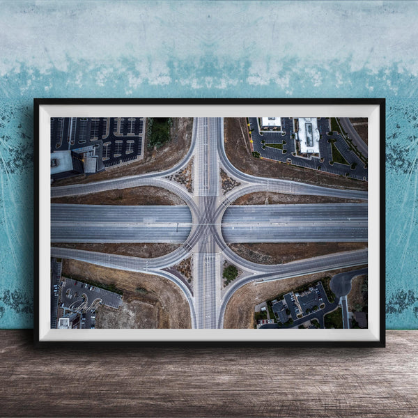 The image is an aerial view of a highway intersection with multiple lanes and exits, surrounded by buildings and greenery.