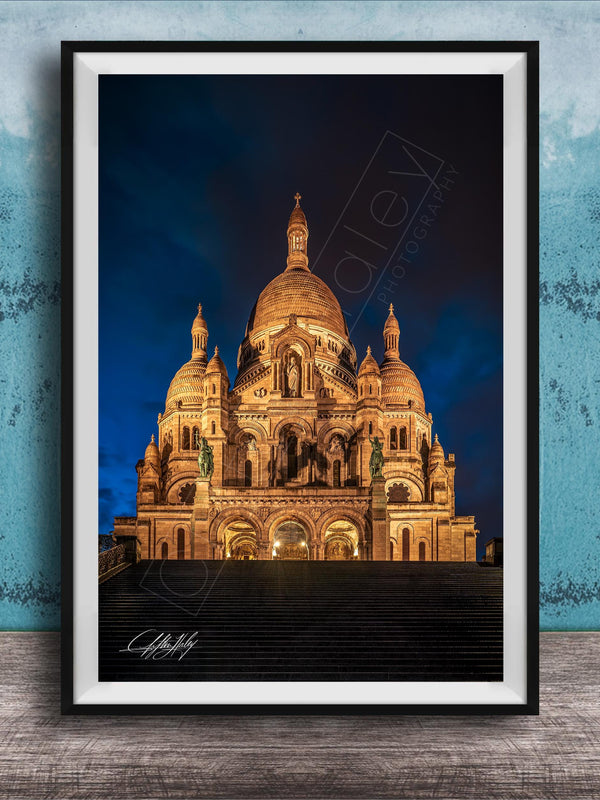 a large, ornate cathedral with multiple domes and towers, illuminated at night against a dark sky.