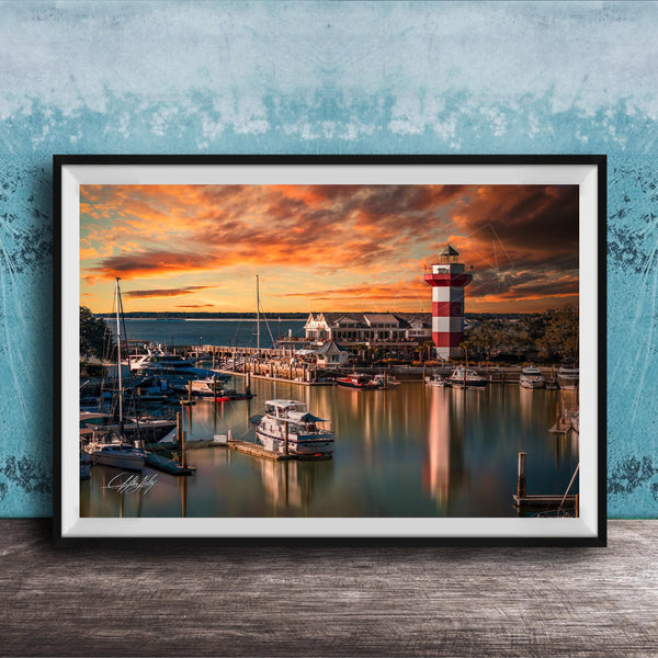 a serene harbor scene at sunset, with boats docked in the calm waters and a lighthouse standing tall in the background.