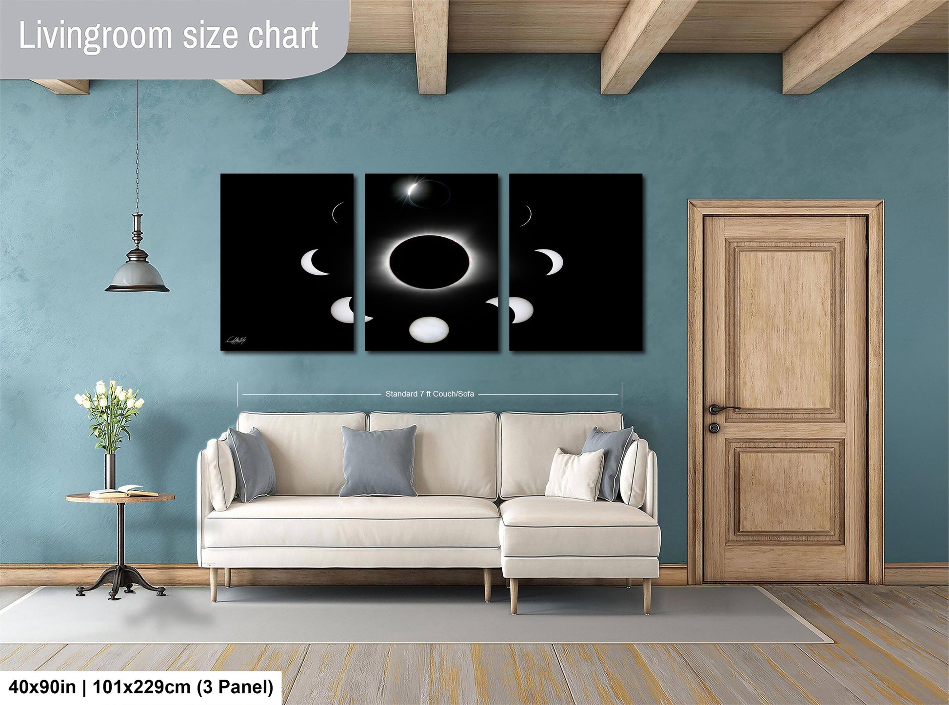 The image is a living room with a white sofa, a wooden door, and a large black and white solar eclipse painting on the wall.