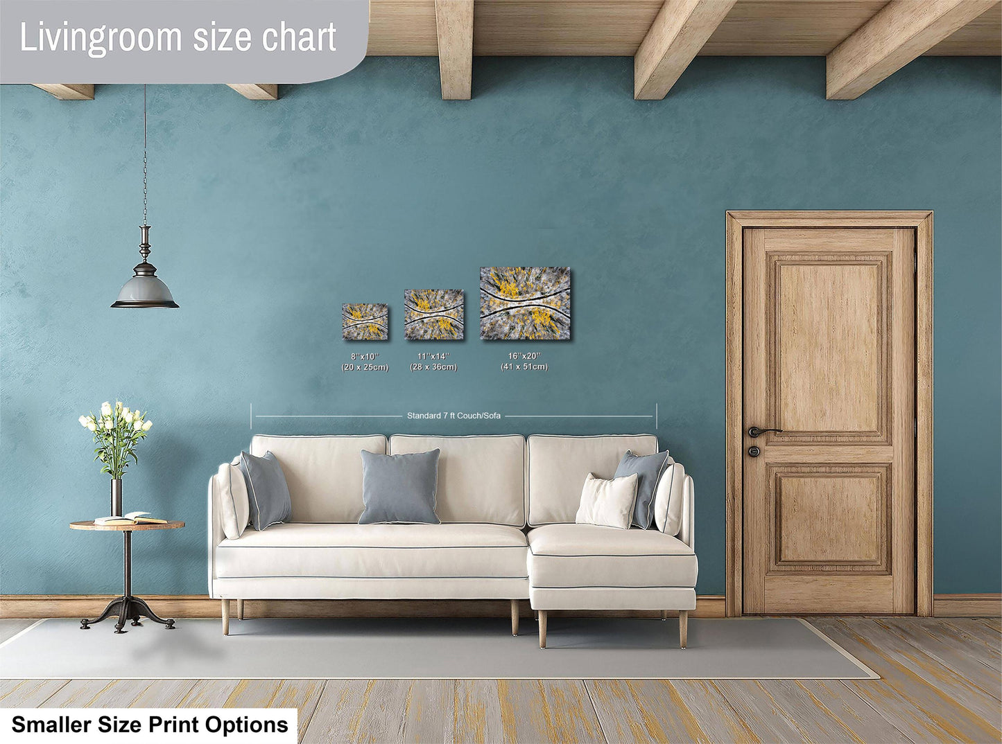 a living room with a white sofa, a wooden door, and a hanging light fixture. There are three framed artworks displayed on the wall above the sofa, and a smaller print size chart is visible below the artworks.
